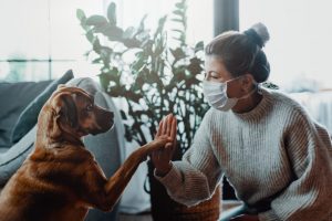 Woman wearing face mask with dog